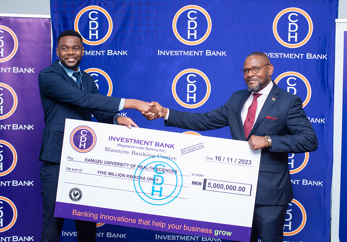 Mr Jamal Kamoto CDHIB Chief Business Development Officer hands over funds to Prof Macpherson Malewa
