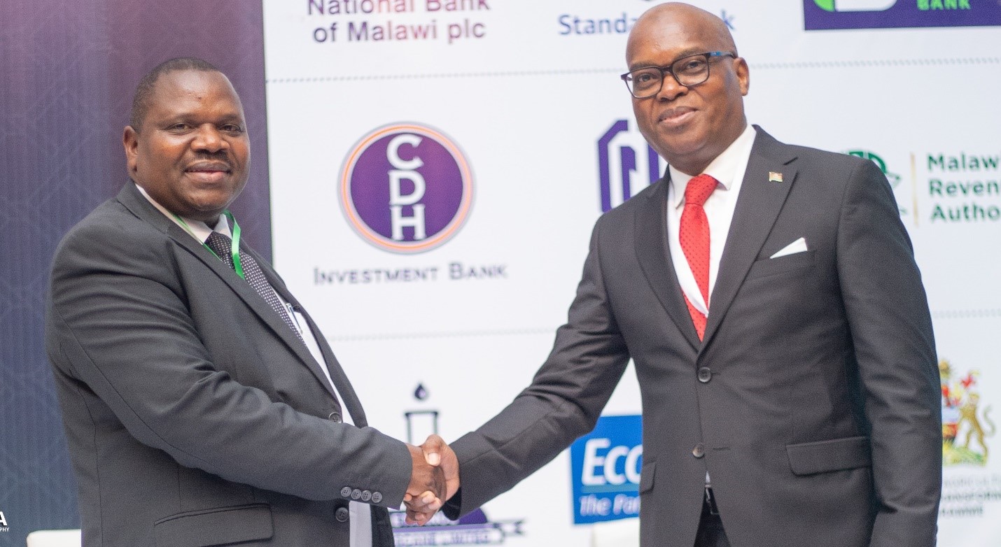 Mr Molius Mangaawuma, CDH Investment Bank Capital City Banking Centre Manager shakes hands with Mr Paul Kwengwere, Malawi Investment and Trade Centre Chief Executive Officer on the sidelines of the meet