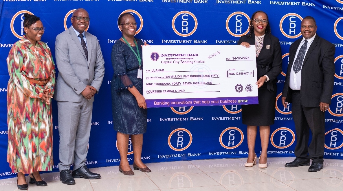 CDH Investment Bank Relationship Manager (Corporate and Public Sector) Mrs Jennie Madinga (2nd right), and CDH Investment Bank Lilongwe Banking Centre Manager Mr Molius Mangaawuma (far right) hands over funds to LUANAR officials (1-3 left)