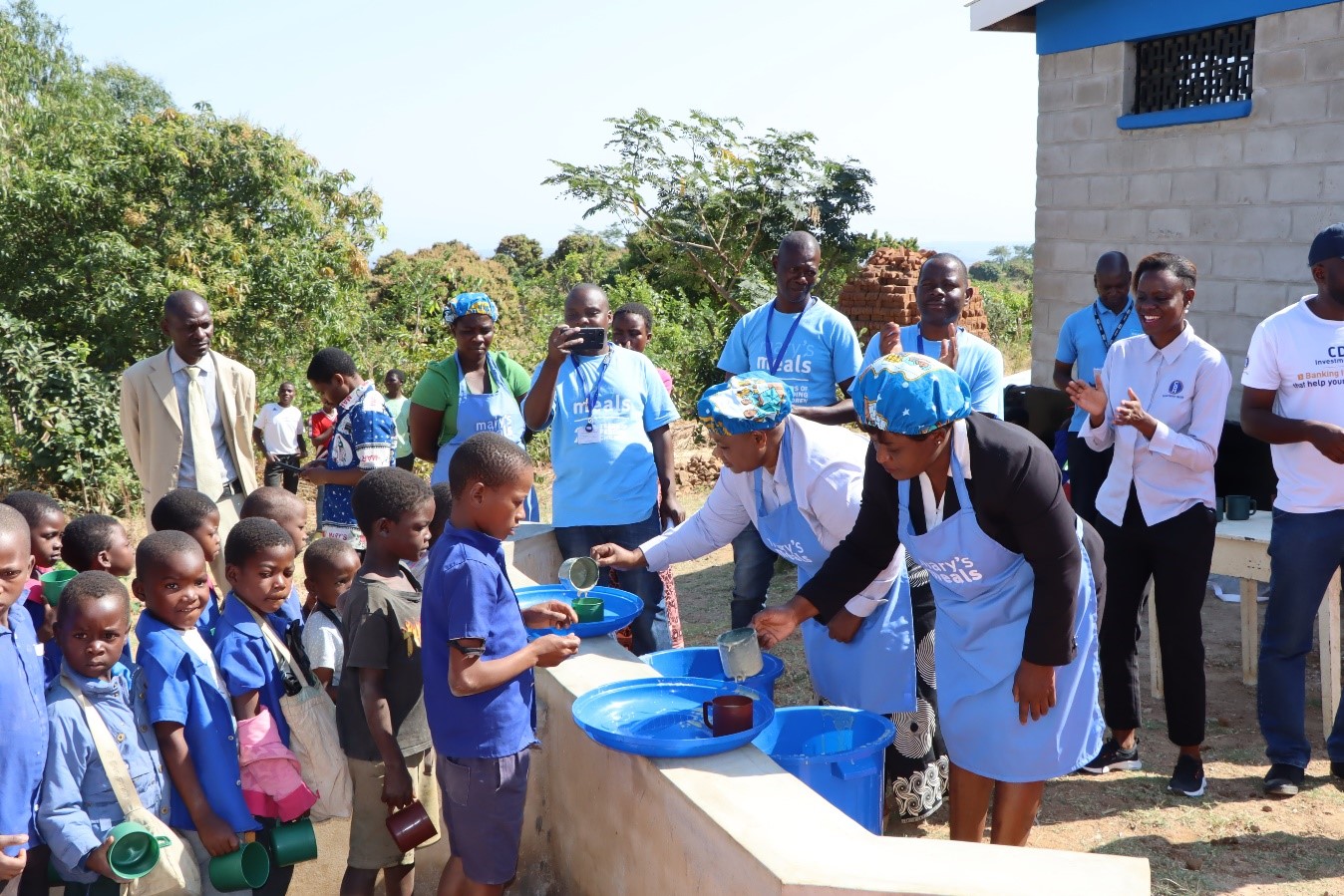 The Guest of Honor, Zelita Zamula participates in the school feeding program along with representatives from CDH Investment Bank and Mary’s Meals Malawi The Guest of Honor, Zelita Zamula participates in the school feeding program along with representatives from CDH Investment Bank and Mary’s Meals Malawi
