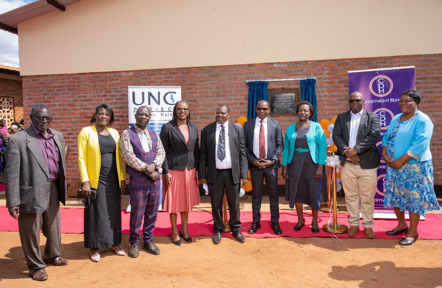 Representatives from Dzama community, UNC Project Malawi, CDH Investment Bank pose with the Guest of Honor Mrs Judith Chiwoko (3rd right) after unveiling the school block building plaque. 