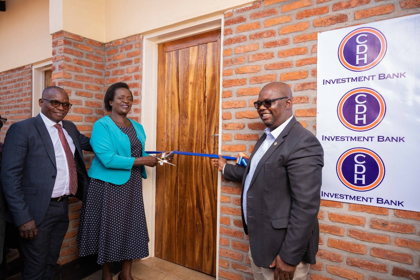 Mr Benison Jambo, CDH Investment Bank Chief Business Development Officer, the Guest of Honor Mrs Judith Chiwoko, The Primary Education Advisor and Mr Innocent Mofolo, PEA, UNC Project Malawi, Country Director cutting ribbon before entering the school block. 